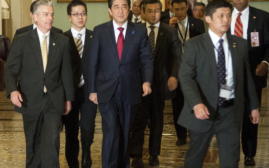 Japanese Prime Minister Shinzo Abe, center, arrives for a meeting on Capitol Hill in Washington, D.C., on Wednesday, April 29, 2015.