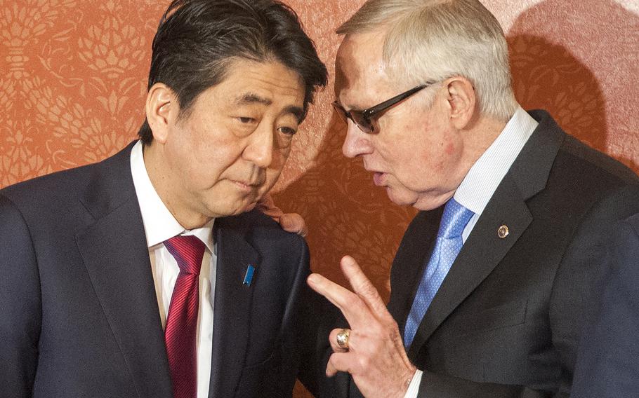 Sen. Harry Reid, D-Nev., has a word with Japanese Prime Minister Shinzo Abe just before a meeting on Capitol Hill in Washington, D.C., on Wednesday, April 29, 2015.