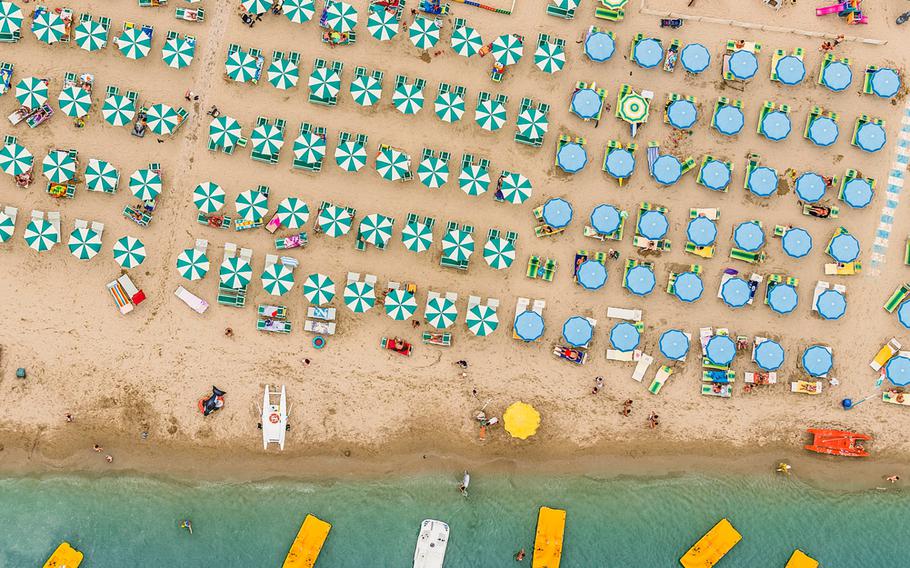 Bernhard Lang, Travel Photographer of the Year | The colorful umbrellas create amazing geometric patterns which contrast dramatically with the golden sand and azure-colored sea. From the air it is possible to see how almost every inch of sand is used on a busy summer's day on the Adriatic coastline.