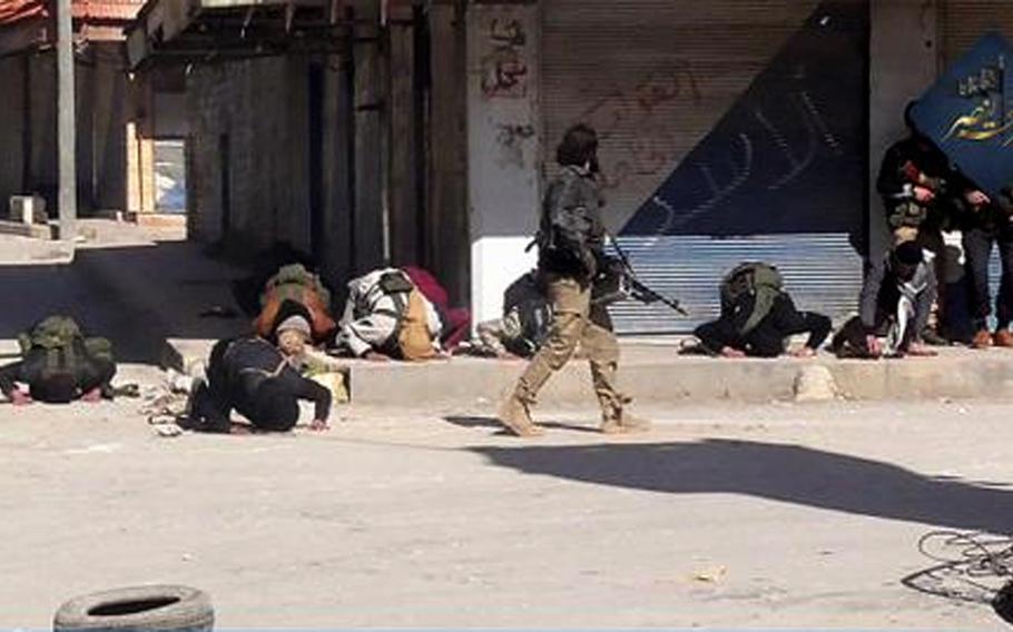 In this file photo posted on the Twitter page of Syria's al-Qaida-linked Nusra Front on Saturday, April 25, 2015, which is consistent with AP reporting, fighters pray after rebel fighters from Islamic factions - including the Nusra Front captured the town of Jisr al-Shughour from Syrian government forces, in Idlib province, Syria. 