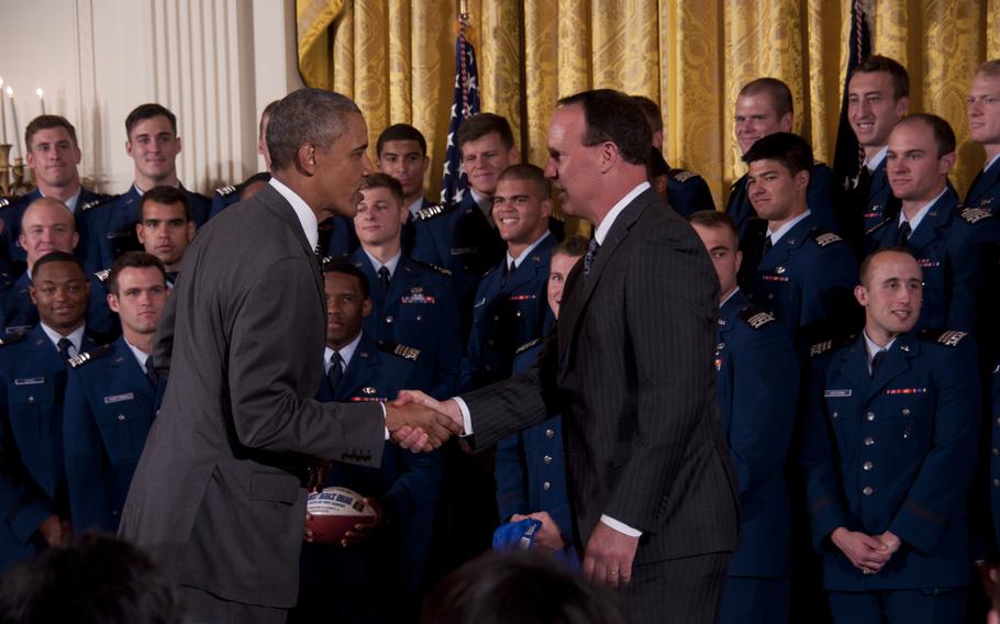 President Barack Obama shakes hands with U.S. Air Force Academy Falcons coach Troy Calhoun while presenting the team the Commander-in-Chief's Trophy at the White House on May 7, 2015. The Falcons beat the Army team 23-6 in November to win the trophy.