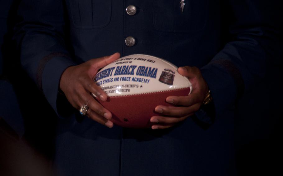 Air Force Academy defensive back Christian Spears holds a game ball for President Barack Obama during a White House ceremony on May 7, 2015. Obama presented the football team with the Commander-in-Chief's Trophy after the Falcons beat Army 23-6 to claim the title.