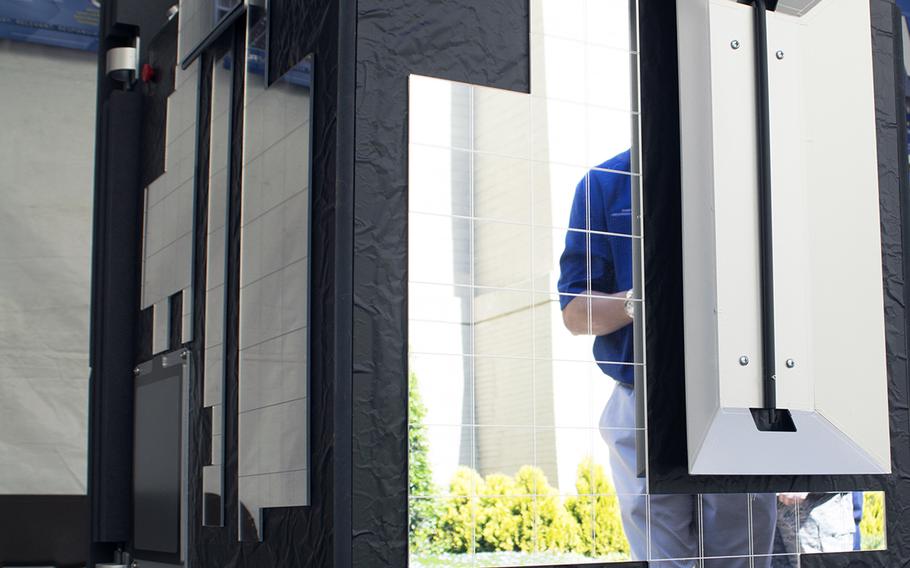 A man is reflected in a satellite on display at the first ever DoD Lab Day at the Pentagon on May 14, 2015. (Meredith Tibbetts/Stars and Stripes)