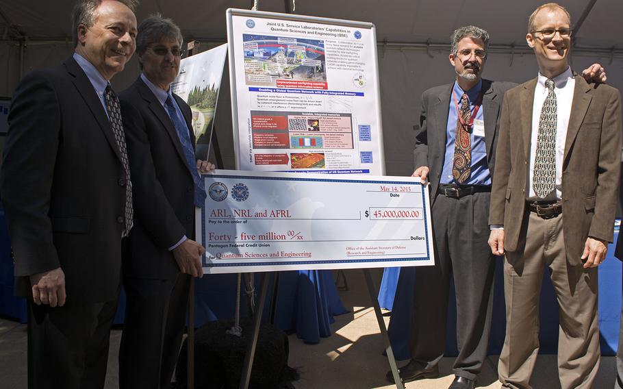 Members of the Joint U.S. Service Laboratories' Capabilities in Quantum Sciences and Engineering - a collaborative Air Force, Army and Navy research team - pose with their check from the DoD. The check for 45,000,000 will help scientists research scalable quantum network technologies.