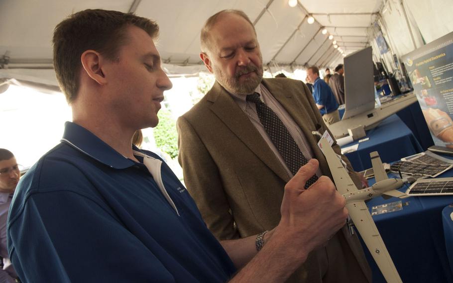 Dan Berrigan (left), a scientist at the Air Force Research Laboratory, explains how 3D printing can produce parts to add onto existing hardware at DoD Lab Day at the Pentagon on May 14, 2015. The lab is also is looking at printing wearable technology.
