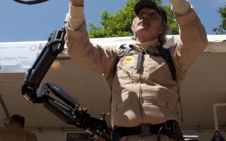 Navy veteran Bill Reason demonstrates an exoskeleton suit meant to help Navy sailors lift and work with heavy items at DoD Lab Day at the Pentagon on May 14, 2015.