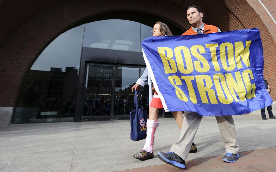 Boston Marathon bombing volunteer first responder Carlos Arredondo holds a "Boston Strong" banner as he leaves the Moakley Federal court with his wife Melida after the verdict in the penalty phase of the trial of Boston Marathon bomber Dzhokhar Tsarnaev, Friday, May 15, 2015. 
