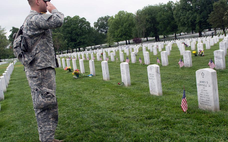 Spc. Nicholas Connell salutes his father, Sgt. 1st Class James D. Connell Jr., who was killed in action in 2007 in Iraq, during the Flags-In at Arlington National Cemetery on May 21, 2015, in Arlington, Va.