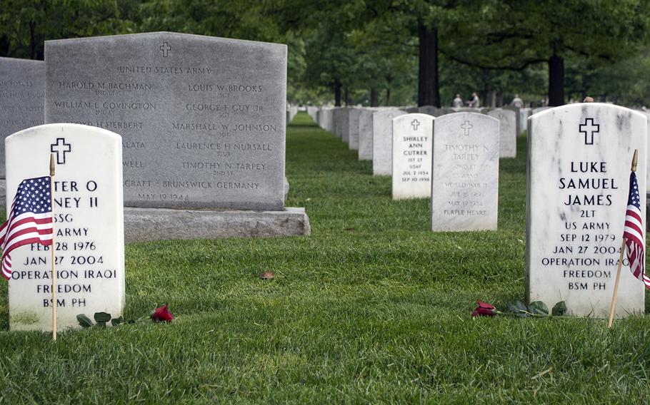 Roses rest near American flags placed at headstones in Arlington National Cemetery during the Flags-In on May 21, 2015.