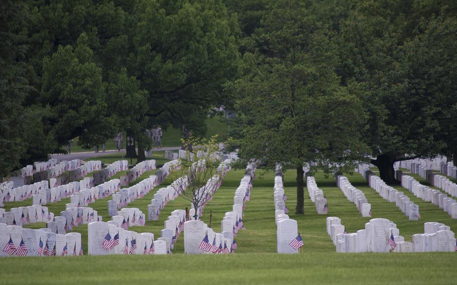 Shadows start to darken the headstones at Arlington National Cemetery Thursday, May 21, 2015, as Flags-In ends. Every headstone received an American flag by the Old Guard, some of which can be partially seen behind the trees. 