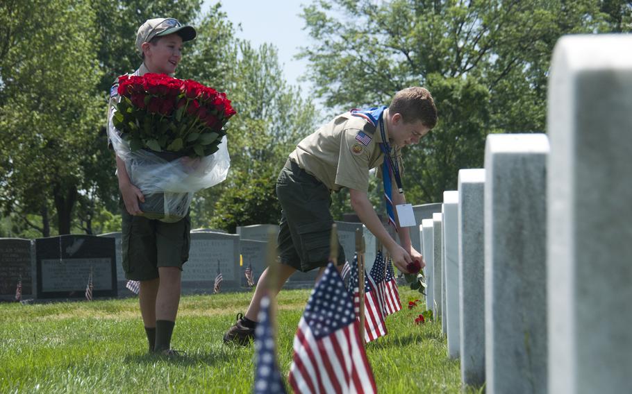 Boy Scounts Jerry Dalrymple (right) and Liam Kellogg (left) of Troop 884 out of Manassas, Va., help lay roses at gravestones at Arlington National Cemetery for Memorial Day on May 24, 2015.