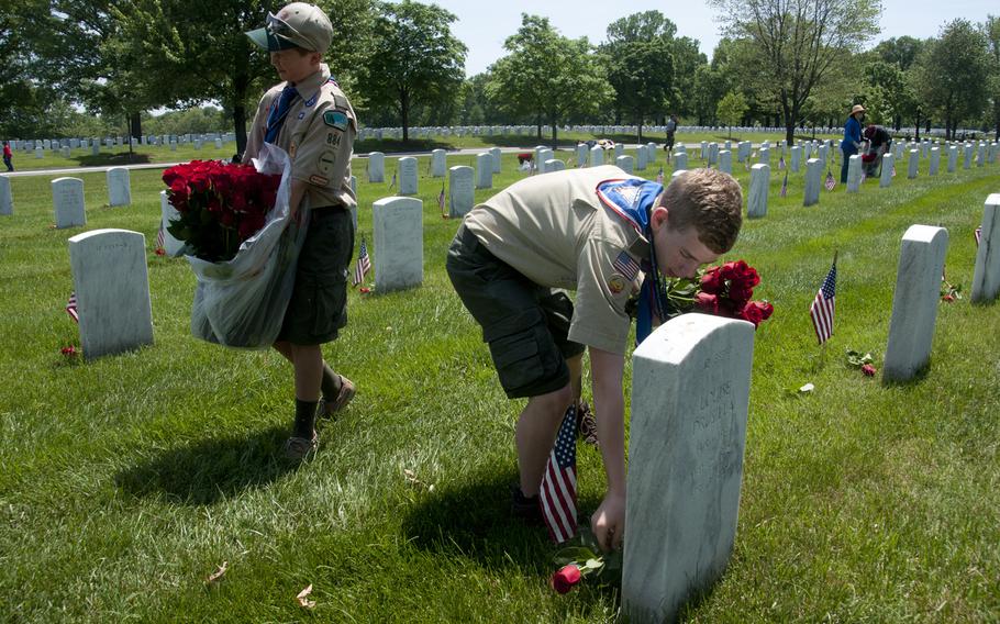 Boy Scounts Jerry Dalrymple (right) and Liam Kellogg (left) of Troop 884 out of Manassas, Va., help lay roses at gravestones at Arlington National Cemetery for Memorial Day on May 24, 2015.
