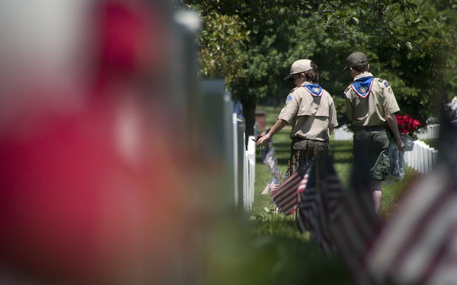 Boy Scouts help lay roses at gravestones at Arlington National Cemetery for Memorial Day on May 24, 2015.