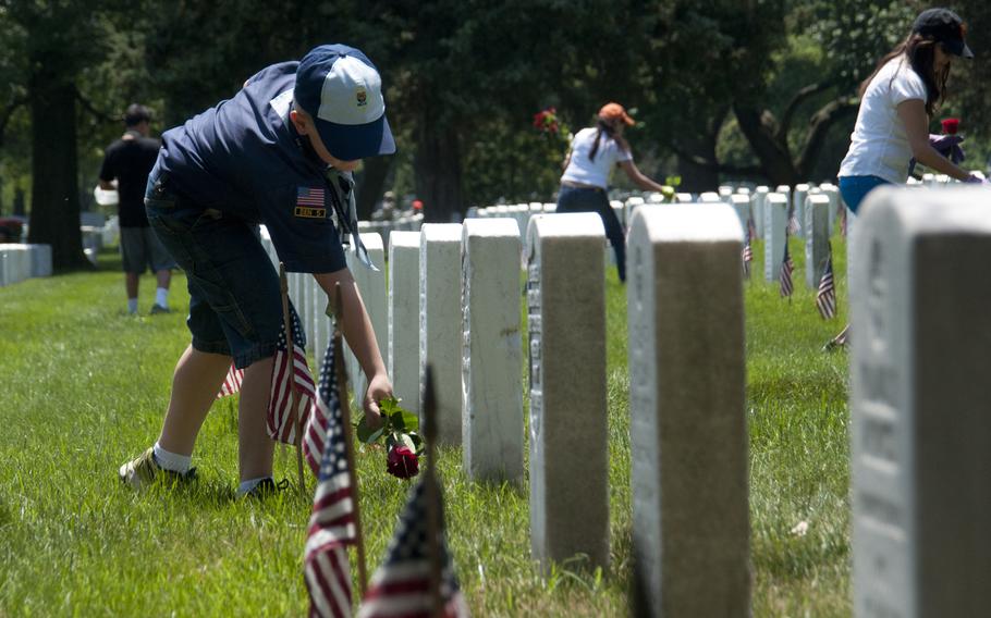 Boy Scout Simon Maly, 9, helps lay roses at gravestones at Arlington National Cemetery for Memorial Day on May 24, 2015.