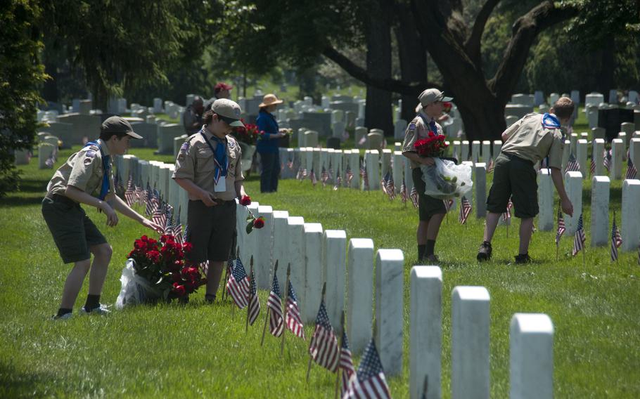 Boy Scouts help lay roses at gravestones at Arlington National Cemetery for Memorial Day on May 24, 2015.