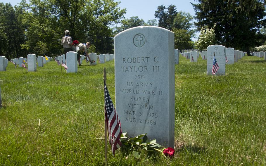 Boy Scouts help lay roses at gravestones at Arlington National Cemetery for Memorial Day on May 24, 2015.