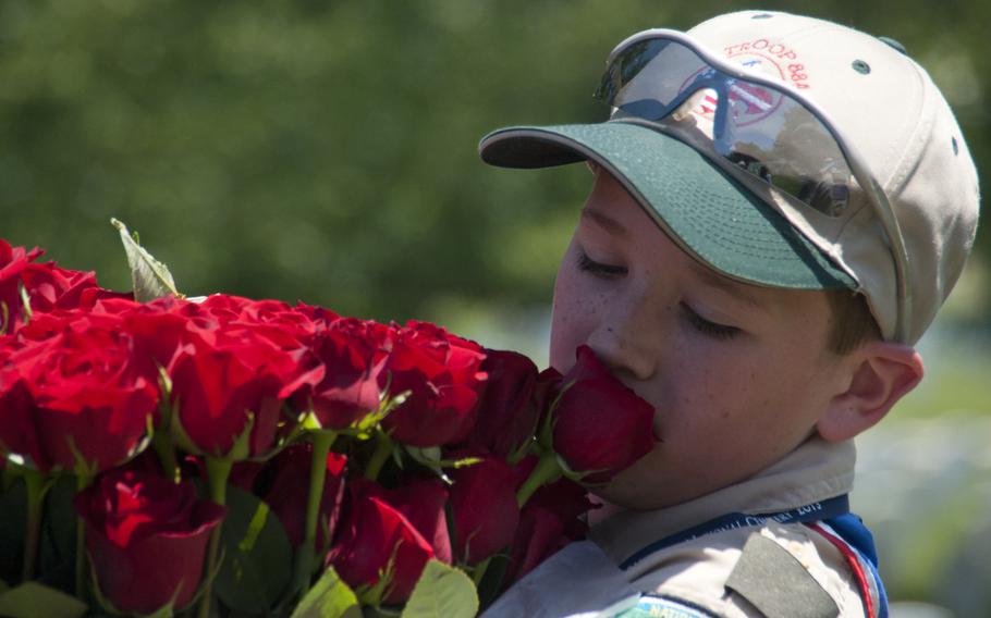 Boy Scout Liam Kellogg of Troop 884 helps lay roses at gravestones at Arlington National Cemetery for Memorial Day on May 24, 2015.