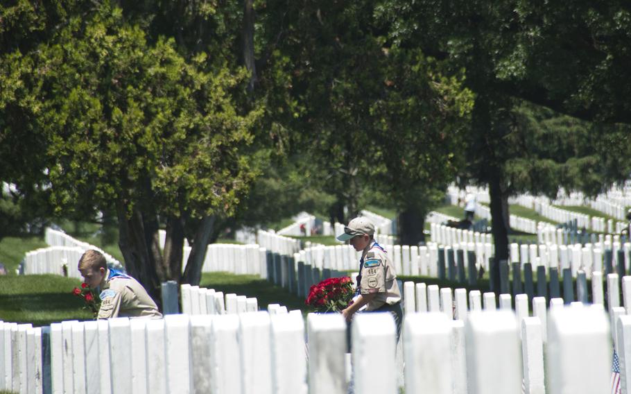 Boy Scouts Jerry Dalrymple (left) and Liam Kellogg, of Troop 884 out of Manassas, Va., help lay roses at gravestones at Arlington National Cemetery for Memorial Day on May 24, 2015.