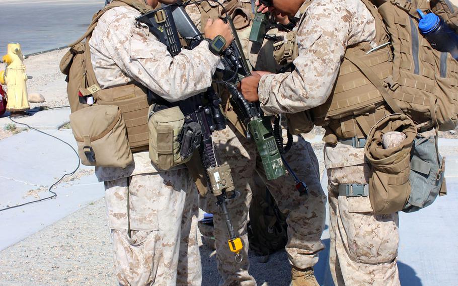 Capt. Jake Dove, commander of Charlie Company, 1st Battalion, 7th Marine Regiment, left, and Cpl. Eric Salazar, right, check their communication equipment at Marine Air Ground Combat Center Twentynine Palms, Calif., before a long-range raid exercise in 2015.