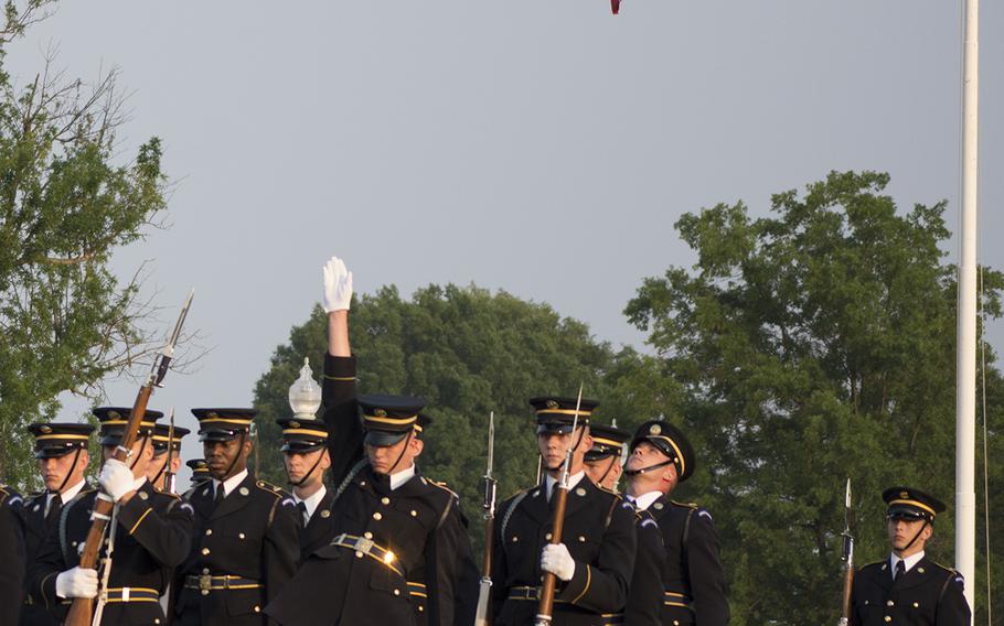 A soldier with The 3rd U.S. Infantry Regiment (The Old Guard) throws his rifle to the back of the group during the Twilight Tattoo at Joint Base Myer- Henderson Hall in Arlington, Va., on June 10, 2015.