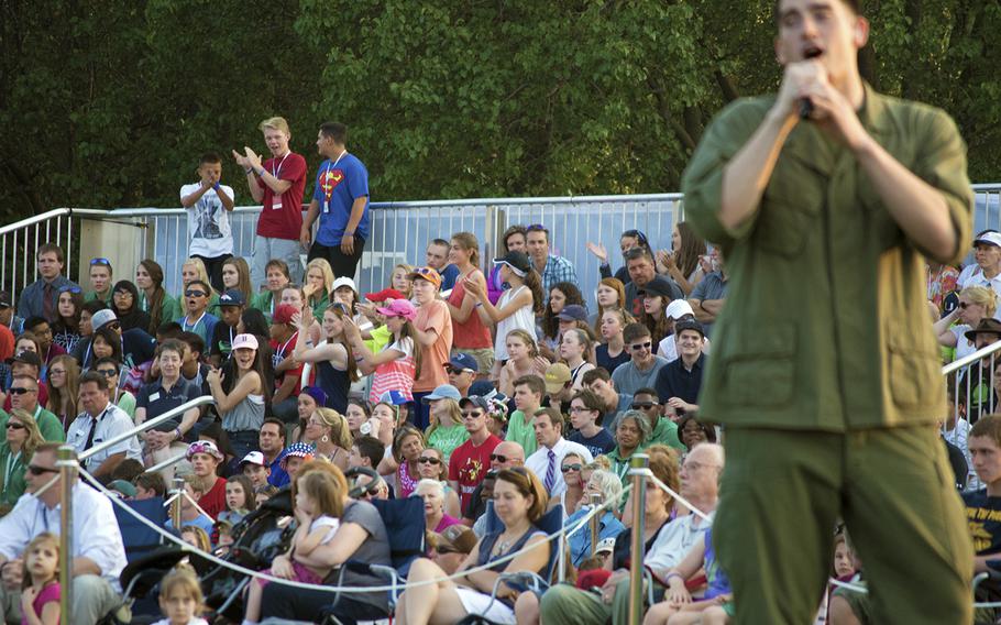 Groups dance while a US Army soldier sings during the Twilight Tattoo at Joint Base Fort Myer- Henderson Hall in Arlington, Va., on June 10, 2015.