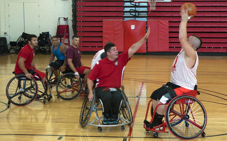 Marine veteran Zachary Blair -- known as "Sharp Shooter," on Team Marine Corps' wheelchair basketball squad -- prepares to launch a shot Thursday, June 18, 2015, during a practice session for the Warrior Games to run from June 19-28 at Marine Corps Base, Quantico, Va. Assistant coach Jaime Baltazar puts an arm up to defend.