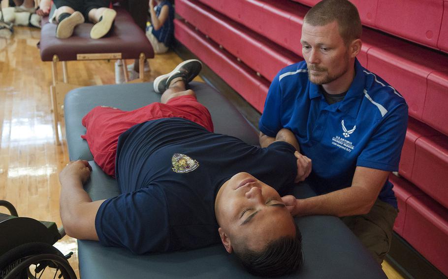 Marine Cpl. Marcus Chischilly, a member of Team Marine Corps' wheelchair basketball team, gets some therapuetic attention from a physical therapist on Thursday, June 18, 2015, after a practice session for the Warrior Games to run June 19-28 at Marine Corps Base, Quantico, Va.