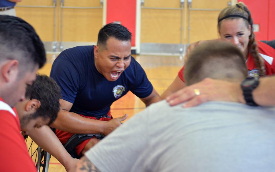 Wounded warriors gather for a victory chant after a scrimmage on June 18, 2015, at Quantico the day before the opening ceremony for the Wounded Warrior Games. Center, facing the photo, is Cpl. Marcus Chischilly.