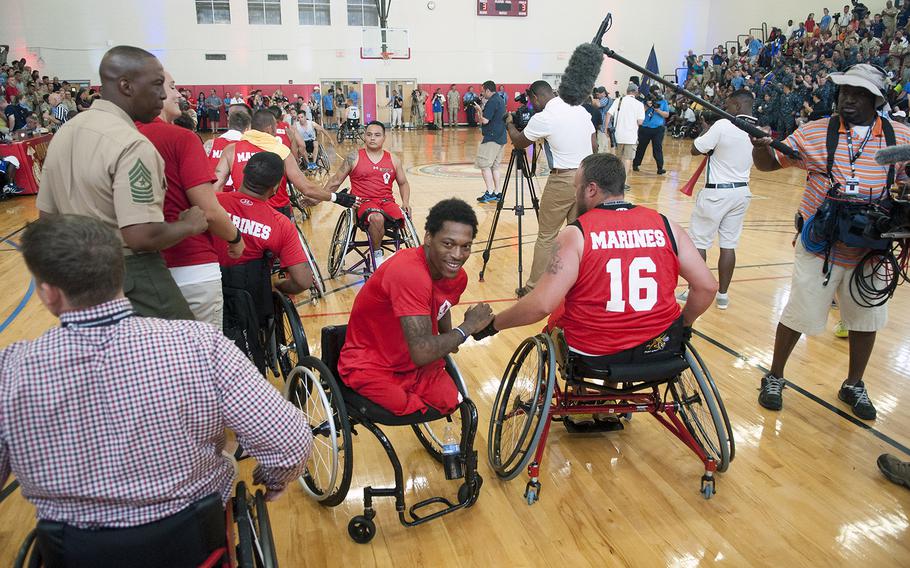 Anthony McDaniel congratulates his former wheelchair basketball teammates Tuesday, June 23, 2015, after Team Marine Corps beat Navy during the Warrior Games championship matchup at Quantico Marine Base, Va. McDaniel, a star player for the team in previous years, was ineligible to play on the team this year after trying out for the U.S. Paralympic basketball team, which placed him in a high-performance pool of players.