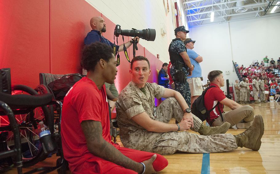 Triple amputee Anthony McDaniel, a medically retired Marine, and Capt. James Ferguson attend the Warrior Games championship wheelchair basketball matchup between Team Marine Corps and Navy at Quantico Marine Base, Virginia on Tuesday June 23, 2015.
