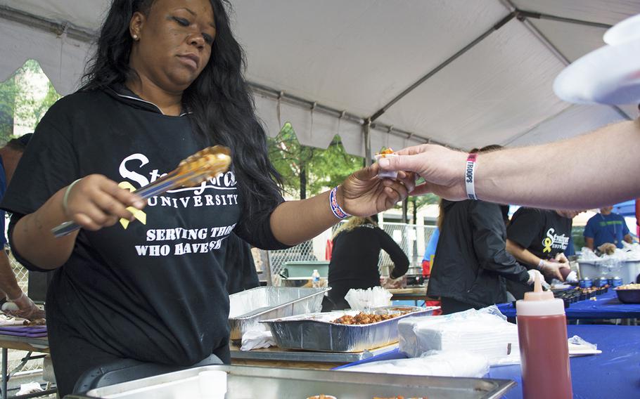 A woman under the US Navy tent doles out samples during the Military Chefs Cook-Off on June 27, 2015, in Washington, D.C.