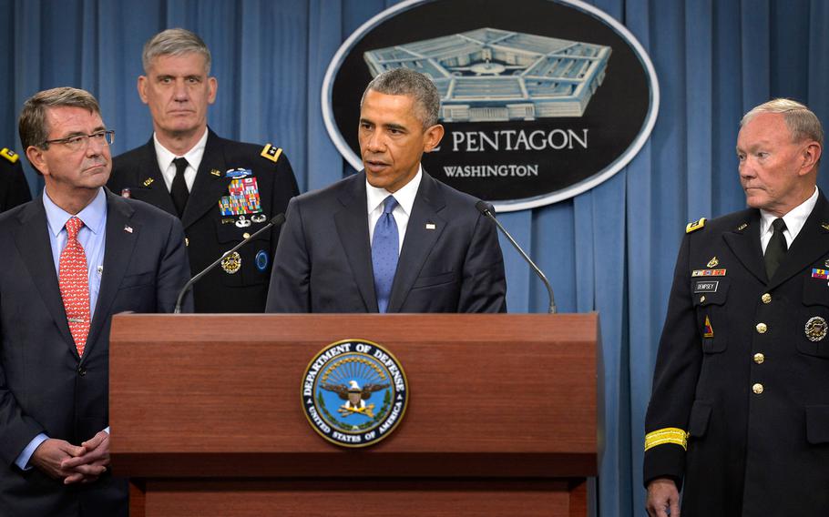 President Barack Obama addresses reporters in a rare appearance at the Pentagon in Washington on Monday, July 6, 2015, flanked by Defense Secretary Ash Carter, left, and Joint Chiefs Chairman Gen. Martin E. Dempsey, right.