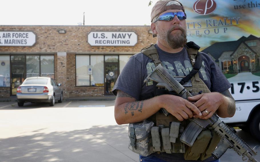 Terry Jackson, a member of Operation Hero Guard, stands guard outside a U.S. military recruiting station in Cleburne, Texas, Tuesday, July 21, 2015. 