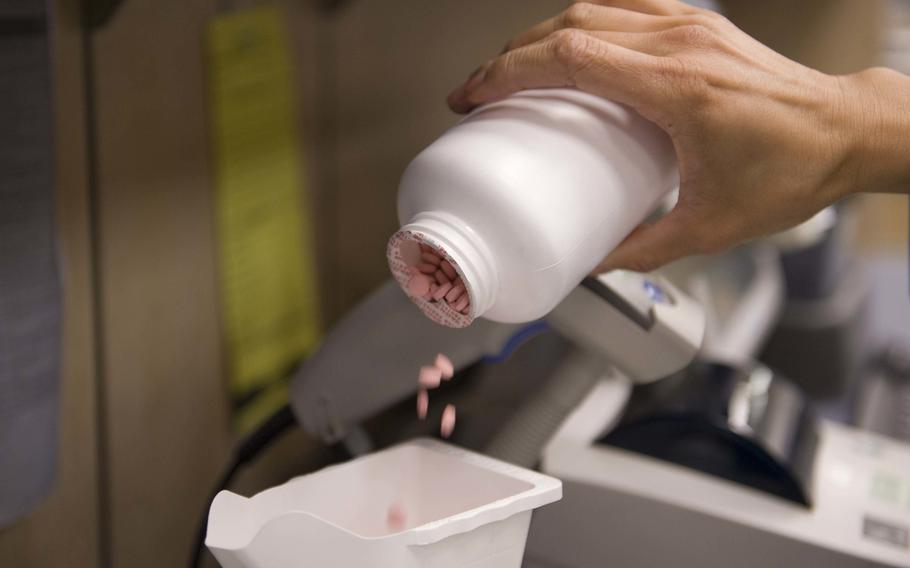 Medicine is poured into a measuring cup at the satellite pharmacy on Nellis Air Force Base, Nev., April 17, 2015. 