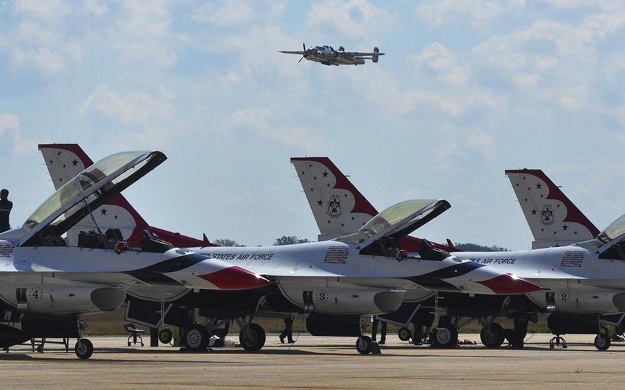 The "Miss Hap" flies above the parked United States Air Force Thunderbirds. The Thunderbirds were the main attraction at the 2015 Joint Base Andrews Air Show.