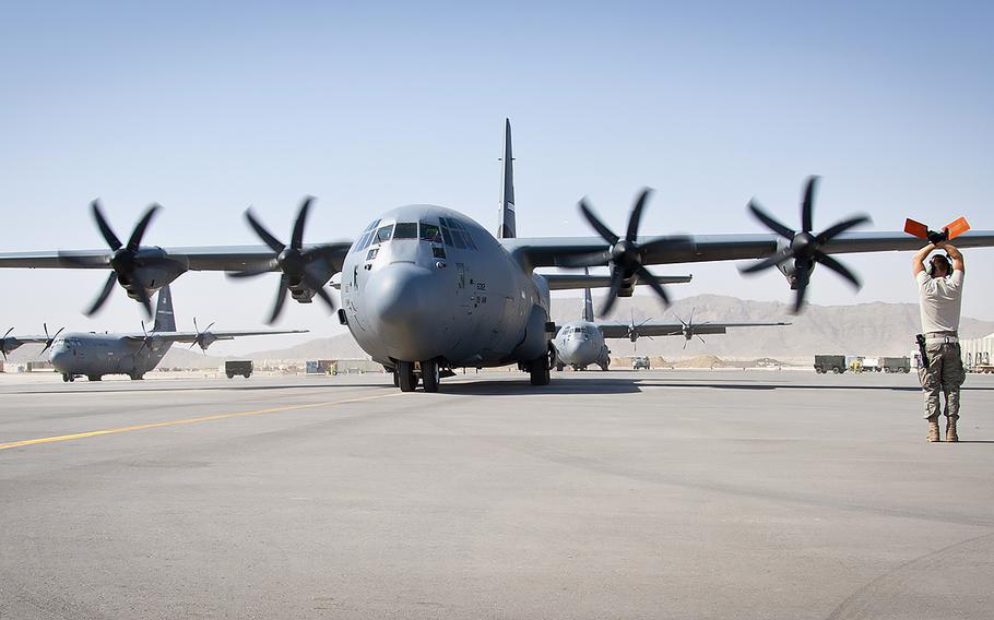 A maintainer from the 772nd Aircraft Maintenance Unit marshals in a C-130J Super Hercules after a sortie at Kandahar Airfield, Afghanistan, Sept. 23, 2011. 