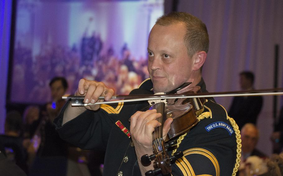 A member of the U.S. Army Strolling Strings band performs among the attendees at the Angels of the Battlefield Gala in Washington, D.C., on Nov. 4, 2015.