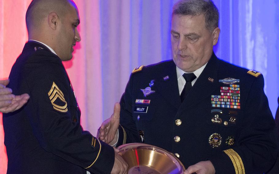 Army Sgt. 1st Class Adam Morelli shakes the hand of Gen. Mark Milley as he receives an award during the Angels of the Battlefield Gala in Washington, D.C., on Nov. 4, 2015. 