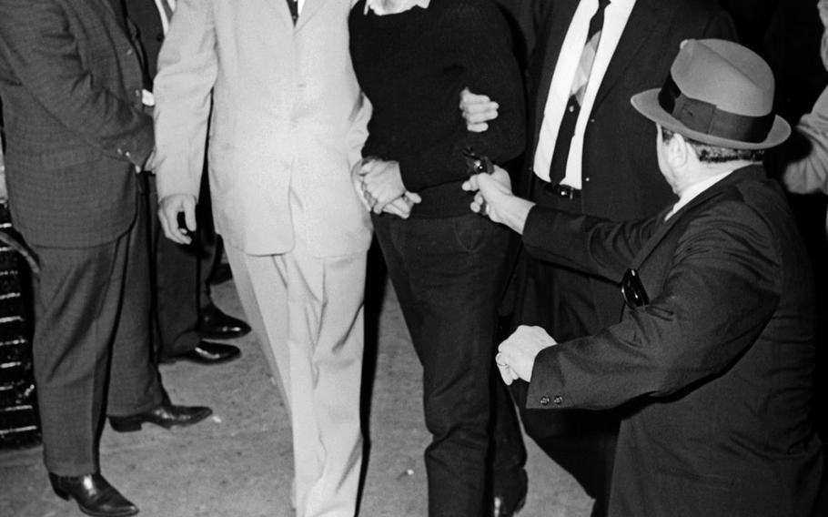 Jack Ruby approaches and shoots Lee Harvey Oswald as he is escorted to the Dallas city jail via the underground garage of the Dallas police headquarters, Texas, on November 24, 1963. Oswald is escorted by detectives Jim Leavelle, left, and L.C. Graves, right.