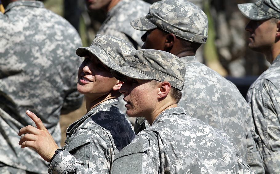 Kristen Griest, left, and 1st Lt. Shaye Haver wait for Ranger School graduation ceremonies to begin at Victory Pond on Aug. 21, 2015 in Columbus, Ga. The two women were the first female soldiers to earn and wear the Ranger tab.