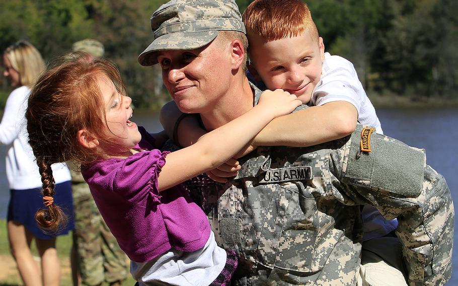 Maj. Lisa Jaster holds her daughter Victoria, 3, and her son Zachary, 7, following Ranger School graduation ceremonies on October 16, 2015, at Victory Pond in Columbus, Ga. Jaster, who was the third woman to earn the Ranger Tab.