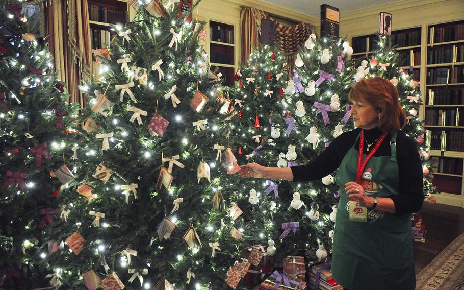 Volunteer Nancy Barsotti shows off Christmas trees paying homage to the 2,700 books housed in the White House library on Dec. 2, 2015. Ornaments include handcrafted book ornaments and snowmen with quote scarves. 