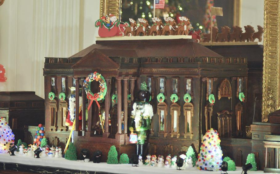 The White House gingerbread house anchors one end of the State Dining Room on Dec. 2, 2015. This year's house weighs nearly 500 pounds, with more thtan 150 pounds of chocolate, and is the first year the East and West Wings have been added. First Lady Michelle Obama hosted a preview of White House decorations for military families on Dec. 2, 2015.