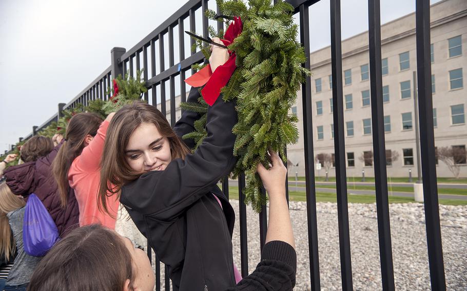 Dozens of volunteers help hang wreaths at the Pentagon in Arlington, Va., on Friday, Dec. 11, 2015, to honor the 184 victims who died on Sept. 11, 2001, when a hijacked aircraft was crashed into the side of the Pentagon.