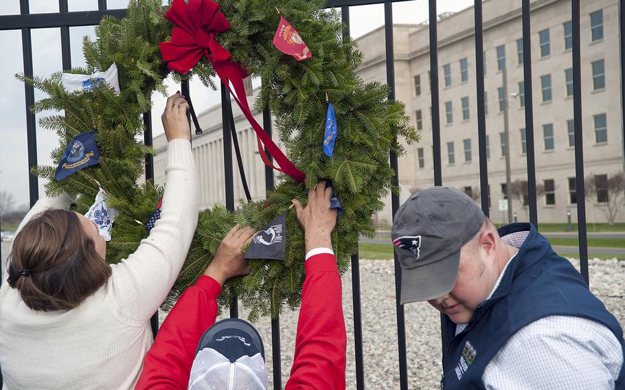 Mike Worcester, right, and his wife, Renee, help hang a ceremonial wreath at the Pentagon in Arlington, Va., on Friday, Dec. 11, 2015. Dozens of volunteers were on hand to hang 184 wreaths in honor of the victims who died on Sept. 11, 2001, when a hijacked aircraft was crashed into the side of the Pentagon.