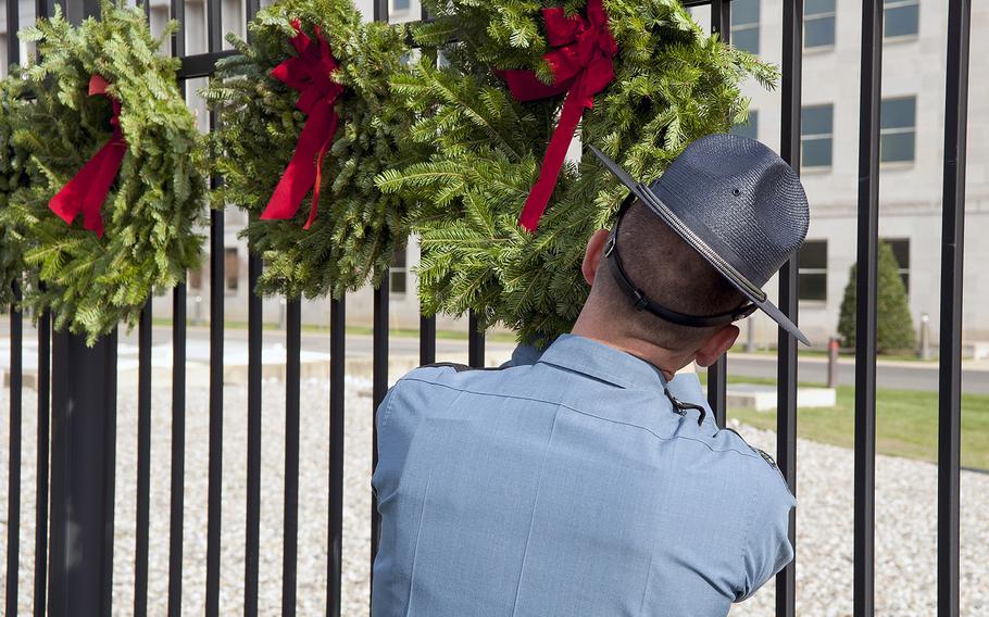 Maine State Police Sgt. Mark Holmquist helps hang wreaths at the Pentagon in Arlington, Va., on Friday, Dec. 11, 2015. The wreaths honored the 184 victims who died on Sept. 11, 2001, when a hijacked aircraft was crashed into the side of the Pentagon.