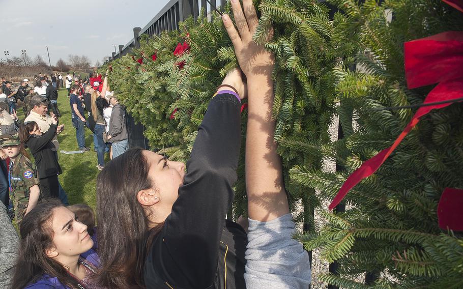 Volunteers help hang wreaths at the Pentagon in Arlington, Va., on Friday, Dec. 11, 2015. The wreaths honored the 184 victims who died on Sept. 11, 2001, when a hijacked aircraft was crashed into the side of the Pentagon.