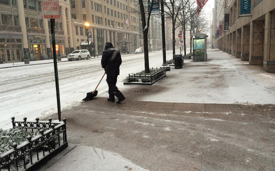 Most of Washington, D.C. cleared out early as a blizzard approached on Jan. 22, 2016, leaving this worker on F Street to try to stay ahead of the storm.