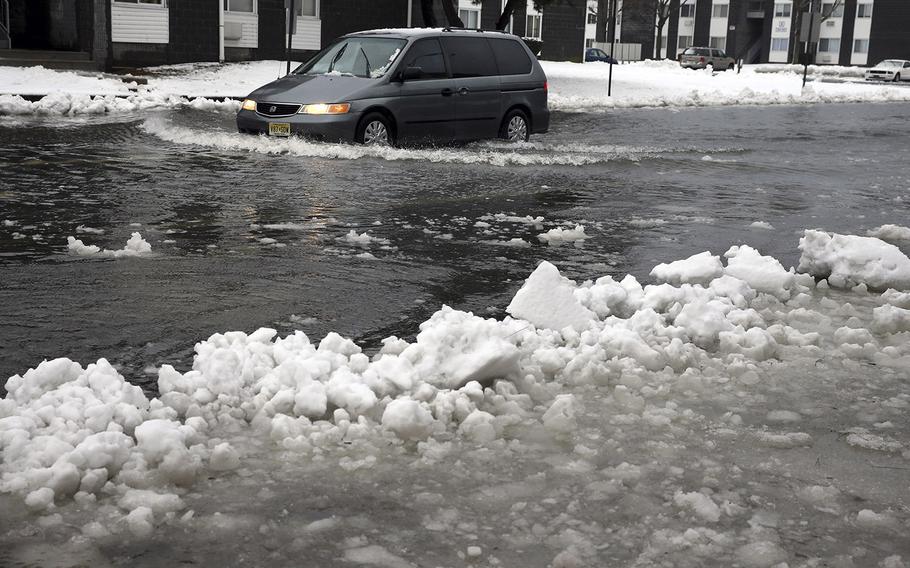 A van drives through a flooded street as ice and snow prevent drainage Saturday, Jan. 23, 2016, in Atlantic City, N.J.