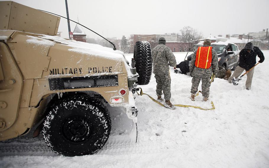 Soldiers with the 275th Military Police Co. and a Washington Firefighter assist a stranded motorist in the snow on I-395, Saturday, Jan. 23, 2016 in Washington, D.C.